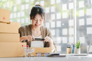 Portrait of a Small Business Startup, SME Owner, Female Entrepreneur work on parcel boxes Receipts a