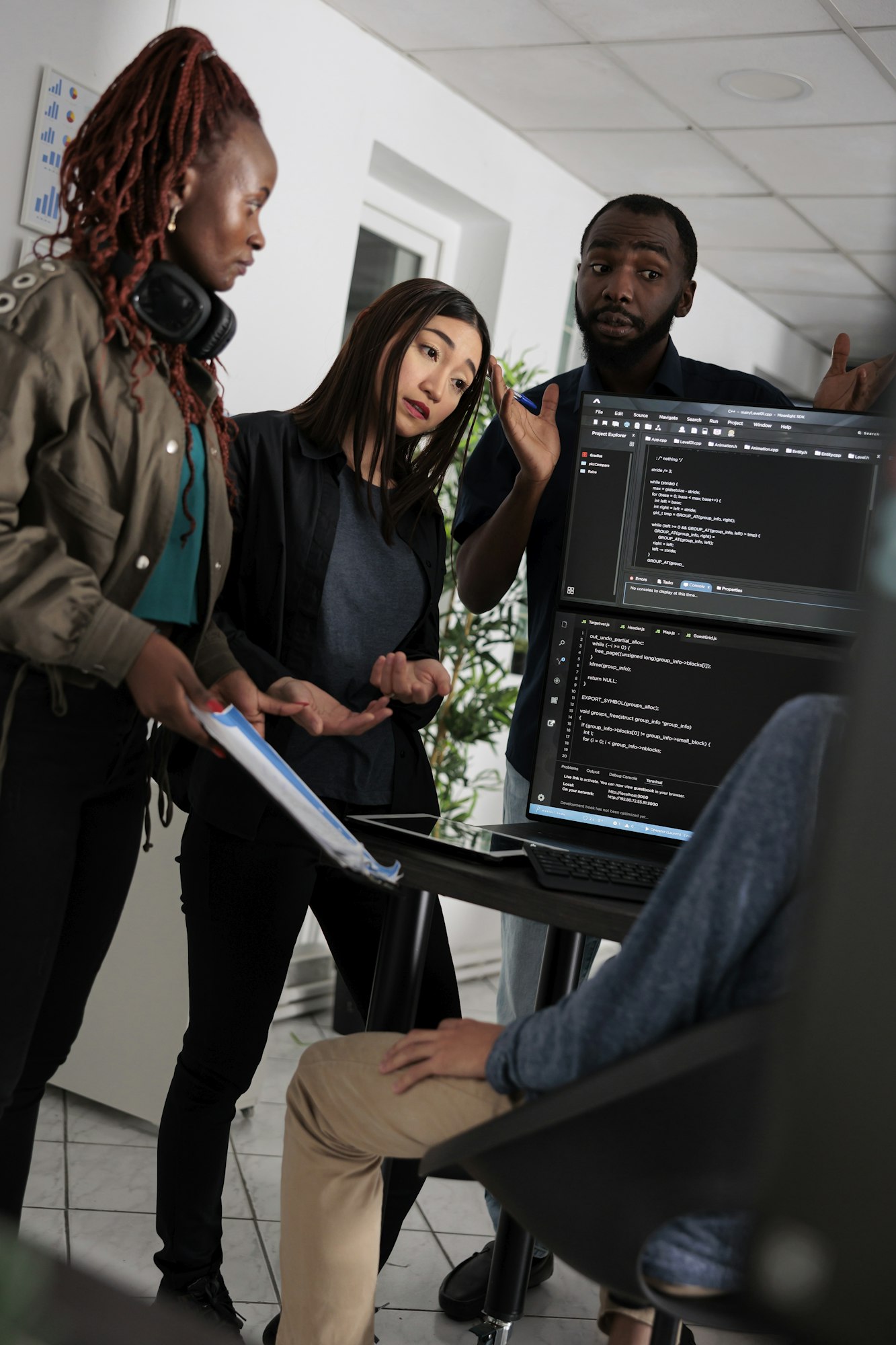 Multi ethnic engineer coding html script information on programming computer at desk